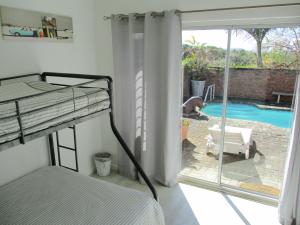 a bedroom with a bunk bed and a view of a pool at Cintsa View in Chintsa