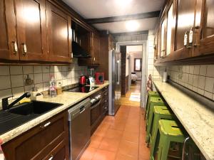 a kitchen with wooden cabinets and a sink and a counter at Poblat Andorrá, Encamp, con terraza, zona Grandvalira in Encamp