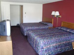 een hotelkamer met 2 bedden en een televisie bij Willow Springs Motel in Cheney