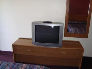 una televisione seduta sopra un comò di legno di Willow Springs Motel a Cheney
