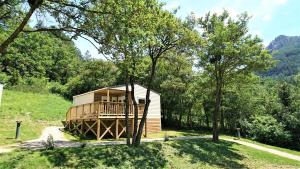a cabin in the middle of a field with trees at Camping White Rock in Castellane