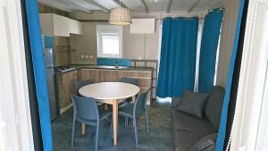 a kitchen with a table and chairs in a room at Camping White Rock in Castellane
