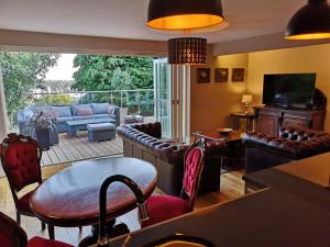 a living room with leather furniture and a patio at The Curate's Quarters at the Old Vicarage in Lincoln