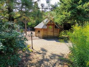 eine kleine Holzhütte in einem Garten mit Bäumen in der Unterkunft Ferienwohnungen Margaretenhof, Plaue in Margarethenhof