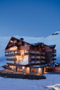 a building with lights in the snow at night at Hôtel Le Sherpa Val Thorens in Val Thorens