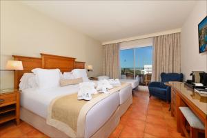 a hotel room with a bed with towels on it at Hotel Fuerte Conil-Resort in Conil de la Frontera