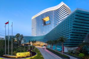 a large building with a curved facade next to a street at Fliport Wutong Hotel-Free Welcome Fruit & Near Exhibition Center in Xiamen
