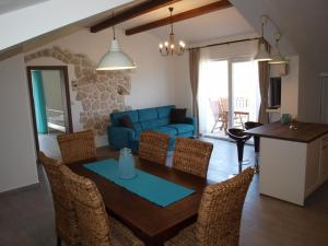 a living room with a table and a blue couch at Apartments Batistić in Supetarska Draga