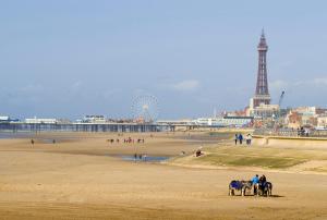 a group of people riding horses on the beach at The Blenheim Mount Hotel in Blackpool