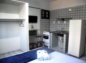 a small kitchen with two slippers on a bed at Praia Apart Hotel in Natal