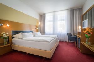 a hotel room with a large bed and a desk at Theatrino Hotel in Prague