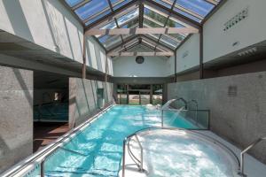 una piscina cubierta con bañera de hidromasaje en un edificio en Hotel Balneario de Compostela en Brion