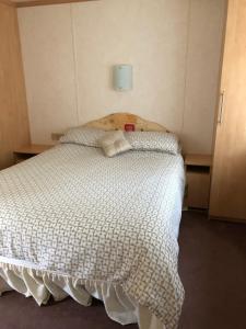 a bedroom with a white bed with two pillows at 57 Glenfinart Caravan Park in Ardentinny