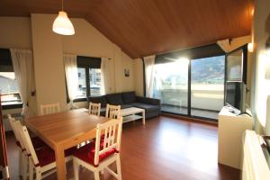 Il dispose d'une cuisine et d'un salon avec une table et des chaises en bois. dans l'établissement Prat del Tirader, Atico en Encamp, Zona Grandvalira, à Encamp