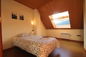 a bedroom with a bed in a room with a window at Prat del Tirader, Atico en Encamp, Zona Grandvalira in Encamp