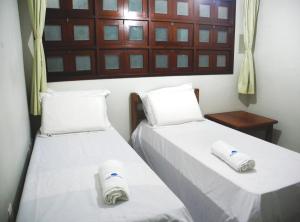 two beds in a room with towels on them at Praia Apart Hotel in Natal
