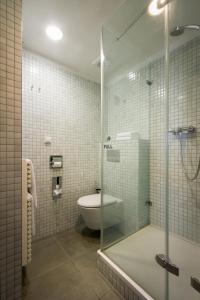 uma casa de banho com um WC e uma cabina de duche em vidro. em Monastery Hotel em Praga