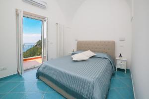 a bedroom with a bed and a large window at Amalfi Dream Charming House in Scala