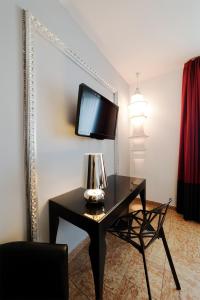 a living room with a television and a lamp at Corte Ongaro Hotel in Verona