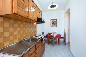 eine Küche mit einem Waschbecken und einem Tisch in der Unterkunft Andreas Pool Complex in Korfu-Stadt