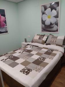 een bed met een geruite deken erop bij Apartamentos Corazón del Húmedo in León