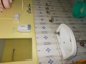 a bathroom with a urinal and a sink on the floor at Hotel Raj Mahal(100 metres from Mall road) in Nainital