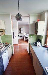 ペーチにあるHygge Apartmentのキッチン(緑と白のキャビネット、テーブル付)