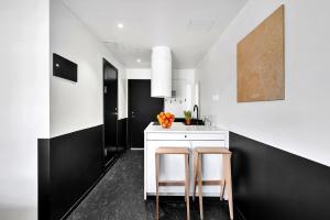 cocina con paredes en blanco y negro, mesa y sillas en Forenom Aparthotel Oslo en Oslo