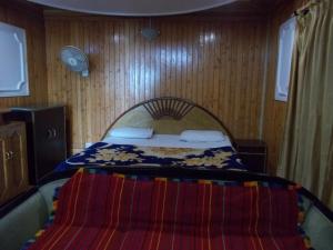 a bedroom with a bed with a blanket on it at Mall road Stay with In-house restaurant in Nainital