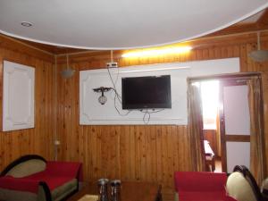 a living room with a tv on a wall at Mall road Stay with In-house restaurant in Nainital