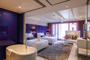 a hotel room with two beds and a bath tub at Hua Chang Heritage Hotel in Bangkok