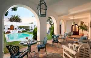 a patio with a table and chairs next to a pool at The Marine Hermanus in Hermanus