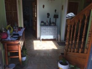 a living room with a staircase and a dresser at aux 2 oies in Plouider