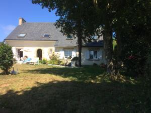 a white house with a tree in the yard at aux 2 oies in Plouider