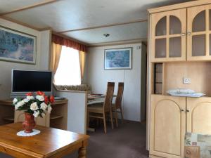 a small room with a table and a desk with a computer at 57 Glenfinart Caravan Park in Ardentinny