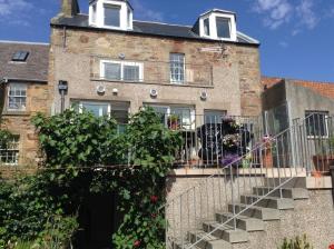 a brick building with a balcony with a dog on it at B&B at 37 in Anstruther