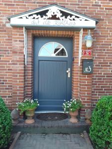 una puerta azul en una casa de ladrillo con dos plantas en dat olde Köhlhus, en Salzhausen