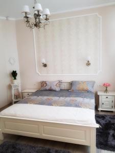una camera da letto con un letto e un lampadario a braccio di Adagio Residence a Constanţa