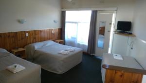 Cette chambre comprend deux lits et une télévision. dans l'établissement The Terang Motor Inn, à Terang