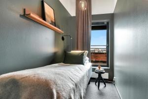 um pequeno quarto com uma cama e uma janela em Forenom Aparthotel Oslo em Oslo
