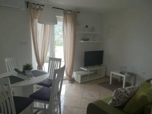 a living room with a table and a television at E&M in Senj