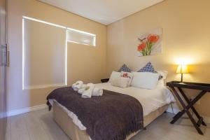 um quarto com uma cama com dois bichos de peluche em Seaside Village B24 by CTHA em Bloubergstrand