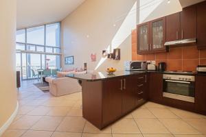 a kitchen with brown cabinets and a living room at Seaside Village B24 by CTHA in Big Bay