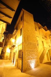 un vieux bâtiment avec un éclairage de rue à côté de celui-ci dans l'établissement ANTICA DIMORA DELL'AMMIRAGLIO, à Licata
