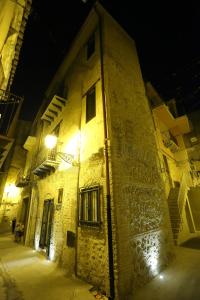 an old stone building with a street light at night at ANTICA DIMORA DELL'AMMIRAGLIO in Licata
