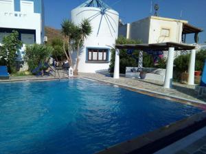 a swimming pool with blue water in front of a house at Efstathia Hotel in Xirokambos