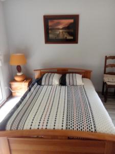 ein Bett mit einem Holzrahmen in einem Schlafzimmer in der Unterkunft Casa Lucia in Saint-Maximin-la-Sainte-Baume