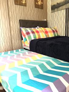 een slaapkamer met een bed met een kleurrijk dekbed bij SMDC Field Residences - SM Sucat in Manilla