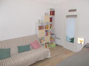 een woonkamer met een bank en een boekenplank bij La Cebette in Saint-Cyr-sur-Mer
