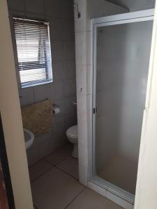 a bathroom with a shower and a toilet at 360 Eastwoods Guesthouse in Pretoria